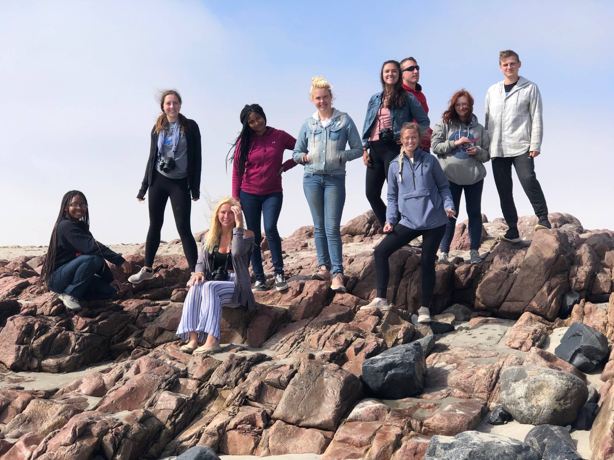 Students posing on rocky ledge in Namibia